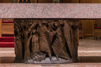 The pedestal is encircled by a bronze bas-relief depicting Old Testament scenes of sacrificial offerings and preparation. 